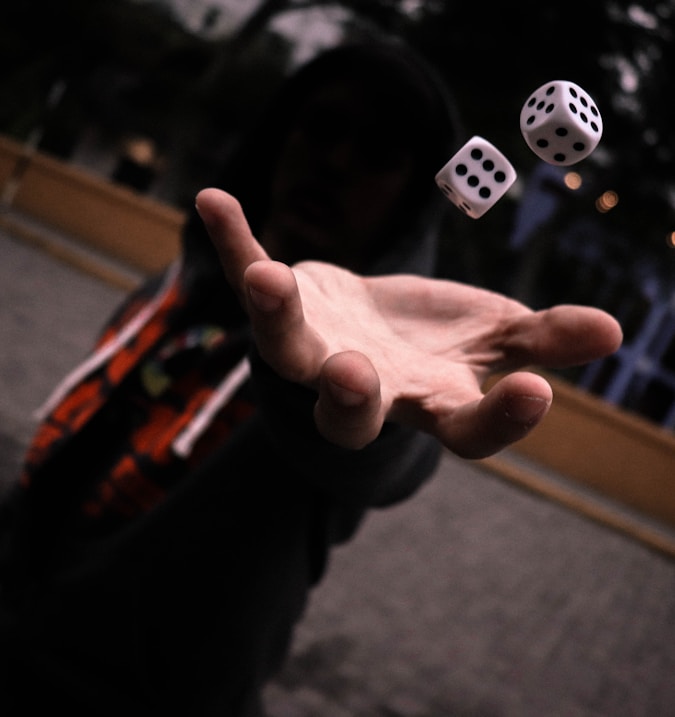 left human hand playing with dice