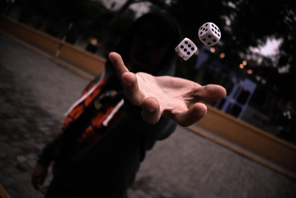 left human hand playing with dice