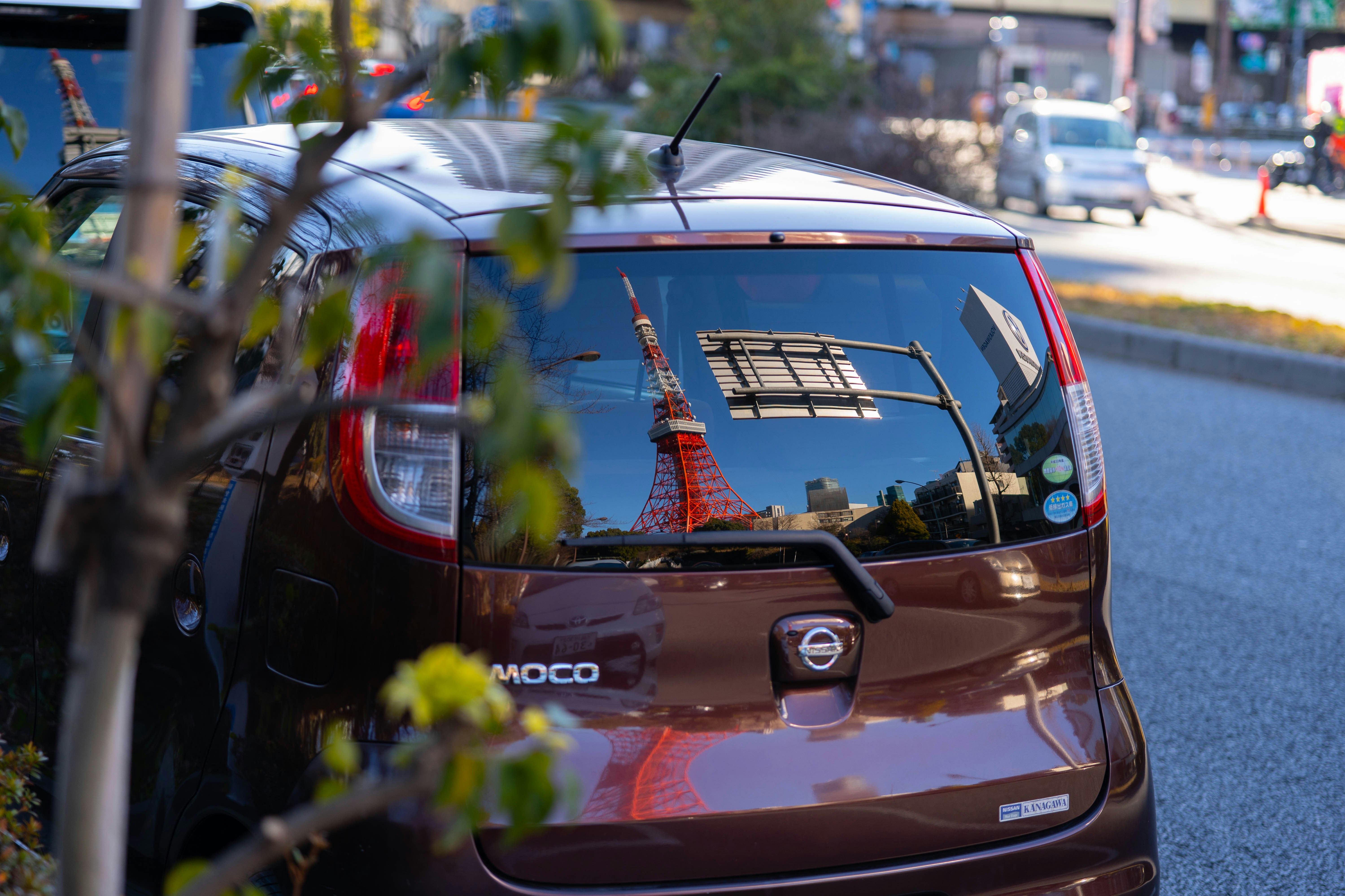 Small electric city car plugged into a curbside charger in an urban street