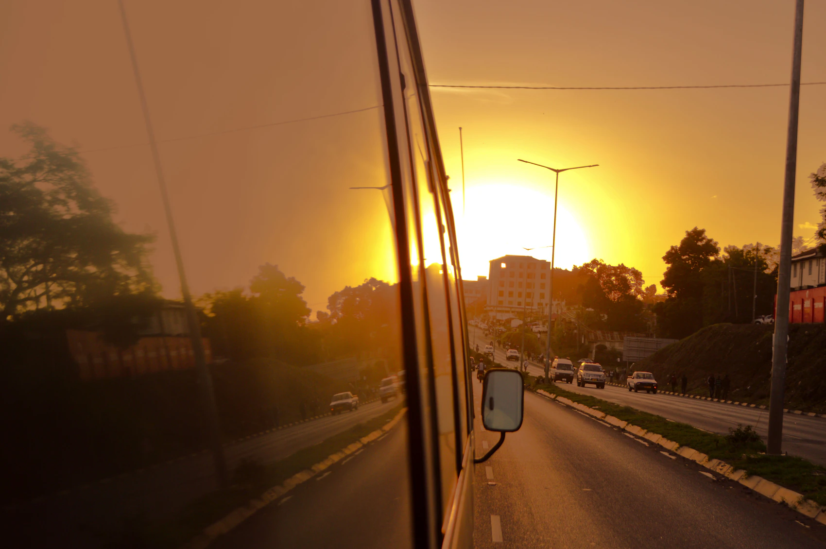 A vehicle travelling through Arusha in warm sunset light