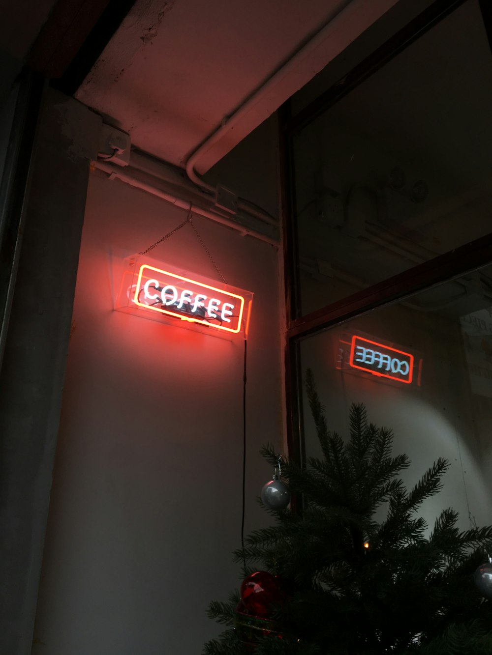 a red coffee sign hanging from the side of a building