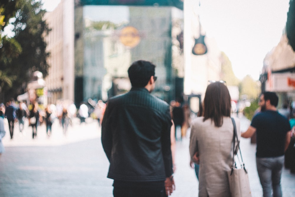 man in black shirt standing in front of people walking on street during daytime