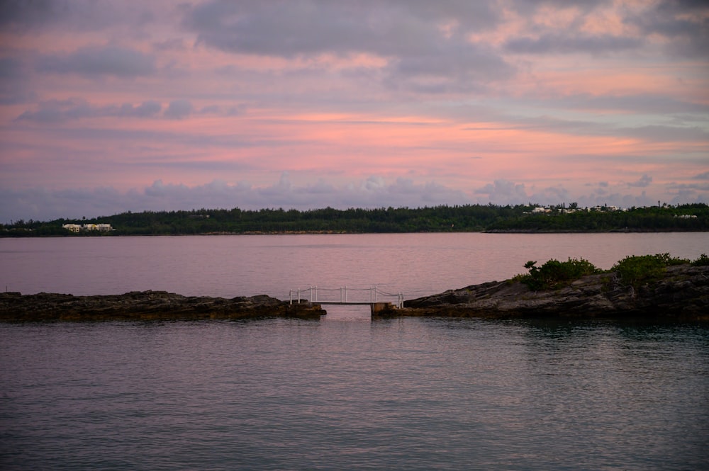 brown wooden dock on body of water during sunset