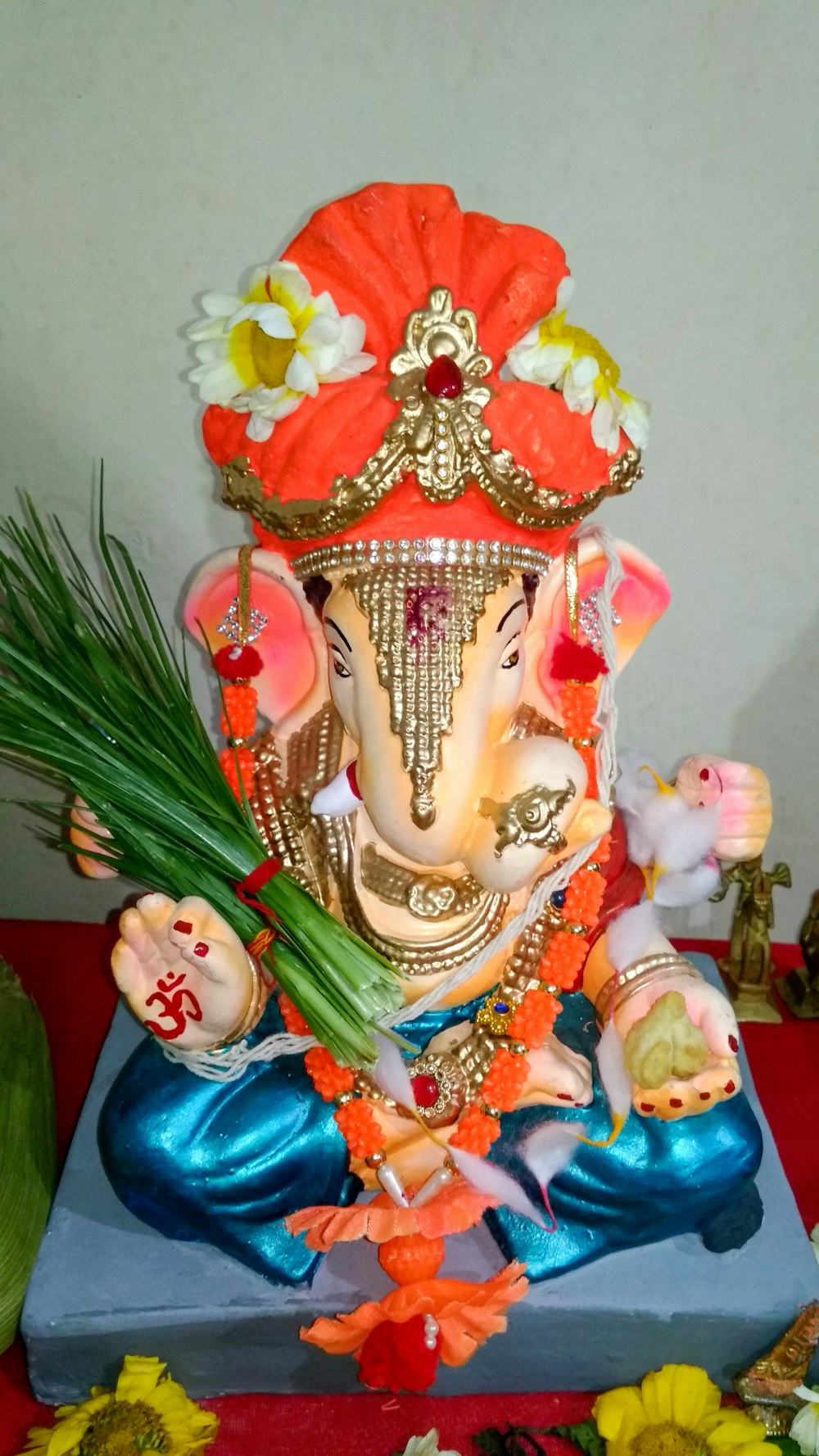 a statue of an elephant with flowers on a table