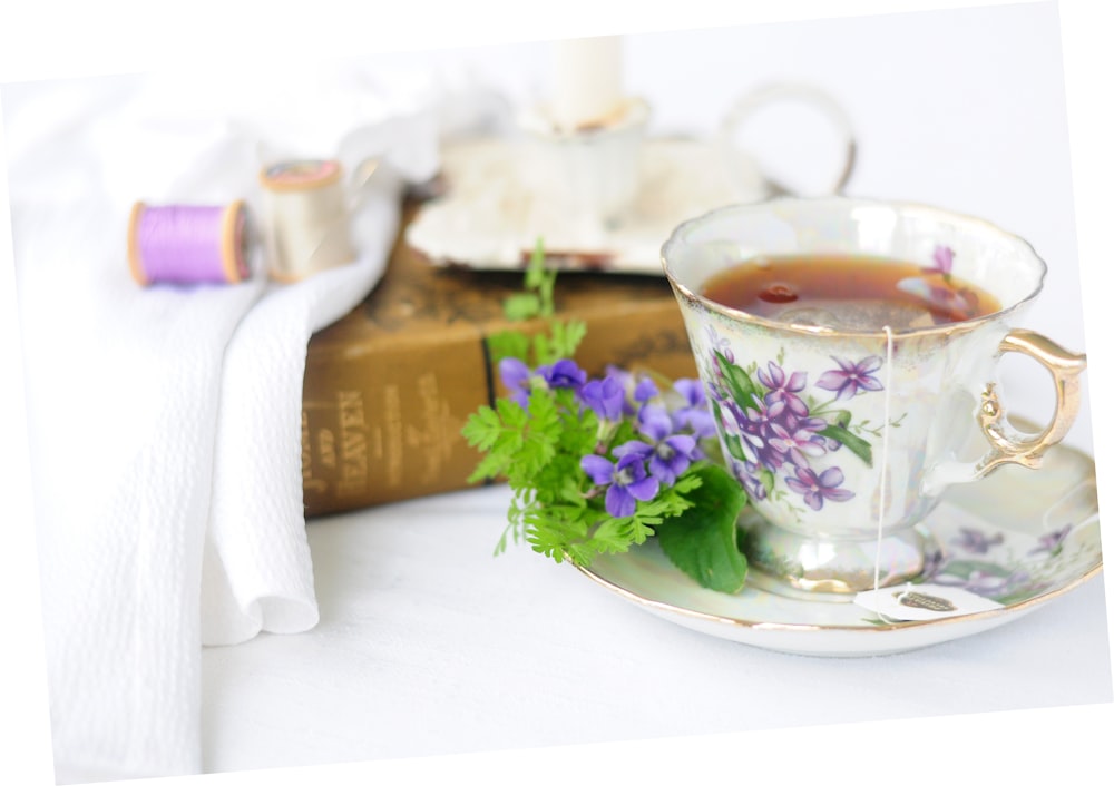 white and purple floral teacup on saucer