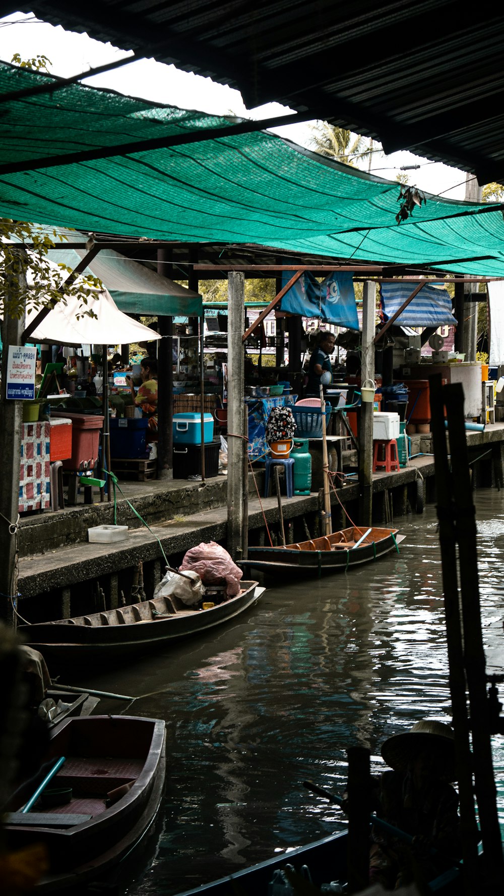 boats docked beside docks with people and stores