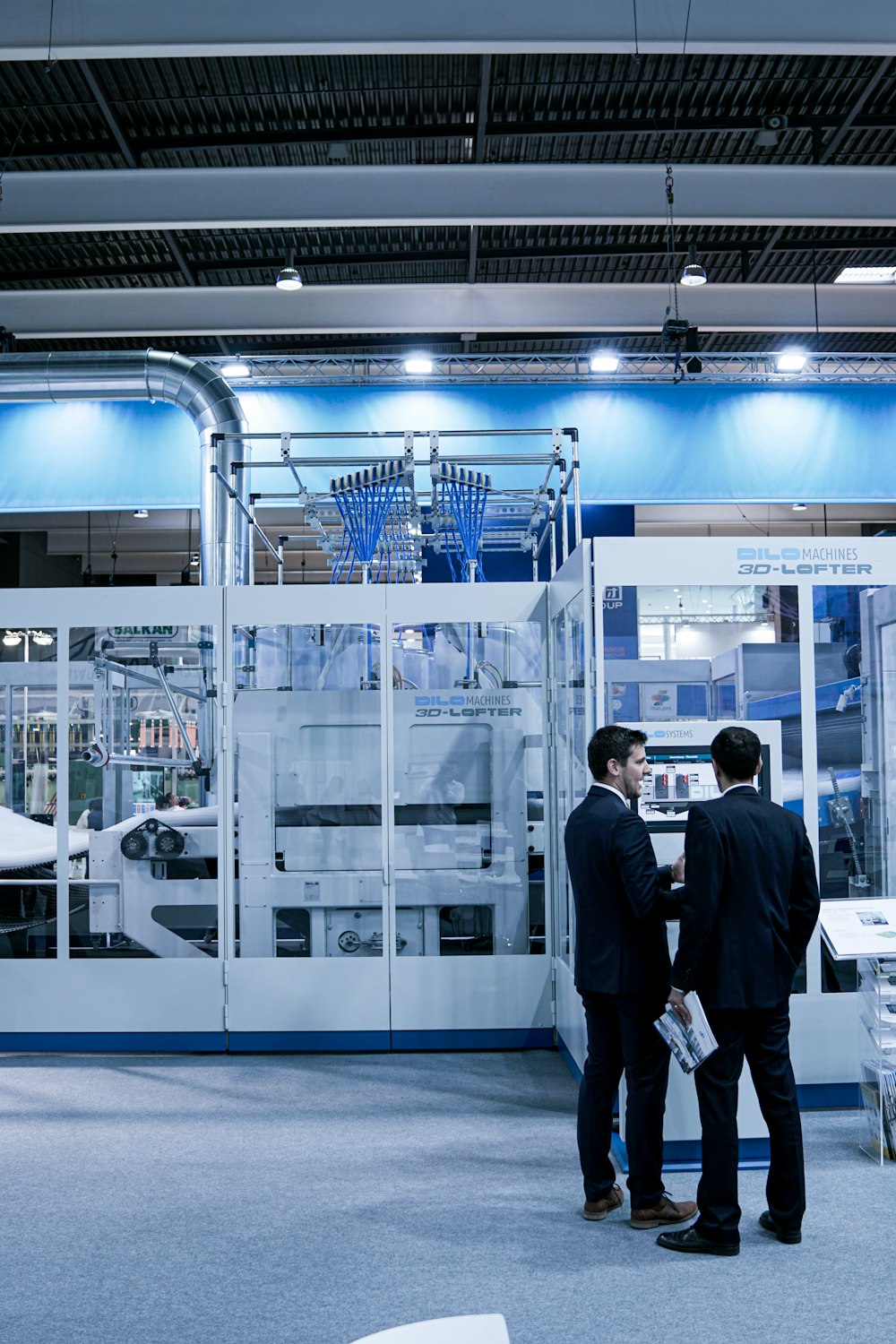 two men standing in front of glass wall