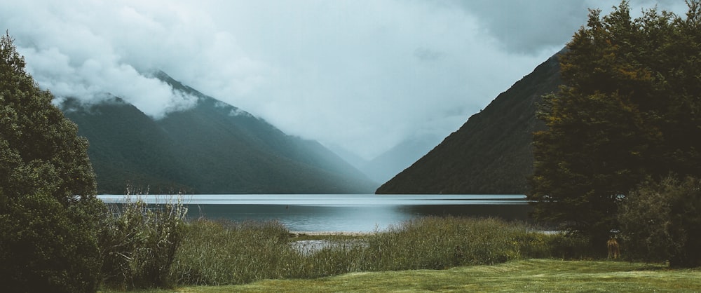 lago cercado por montanha em fotografia de natureza