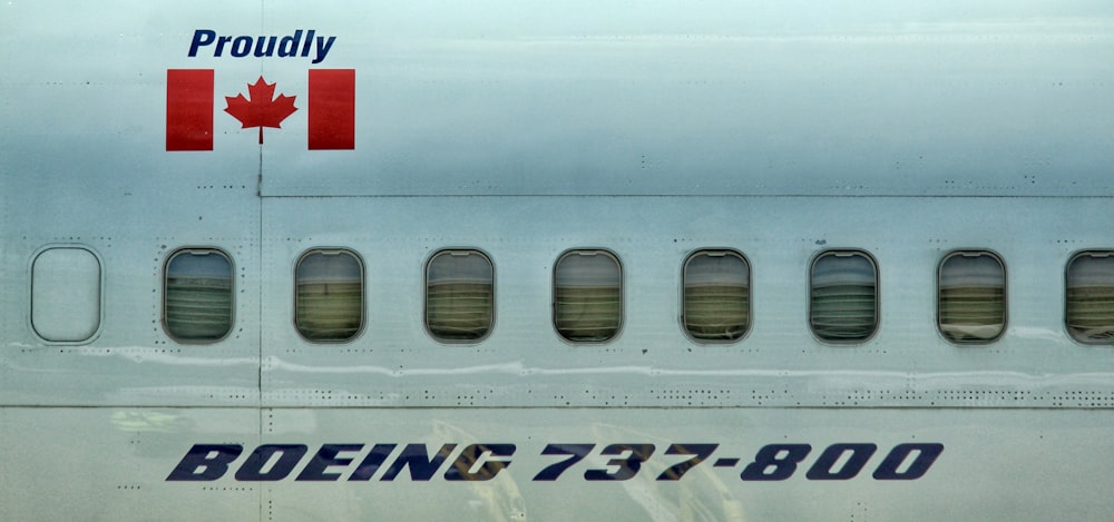 Un primer plano del costado de un avión con una bandera canadiense