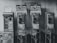 A vintage scene featuring three old-fashioned payphones with rotary dials, alongside a coin-operated machine on a wall with graffiti. The signage includes pricing information and is written in Thai. The environment suggests a public space with signs of wear and nostalgia.