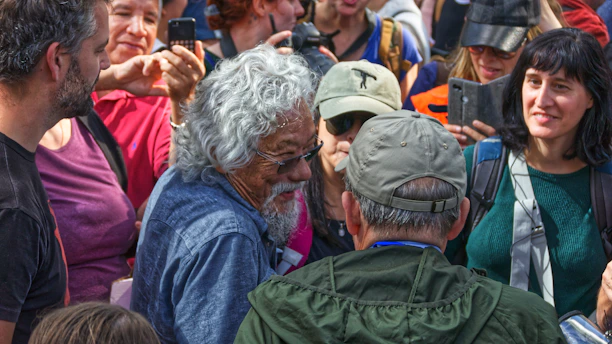 A warm photo of a community gathering with black men and families sharing stories outdoors.