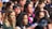 A diverse group of people engaged in a lively makeup workshop.