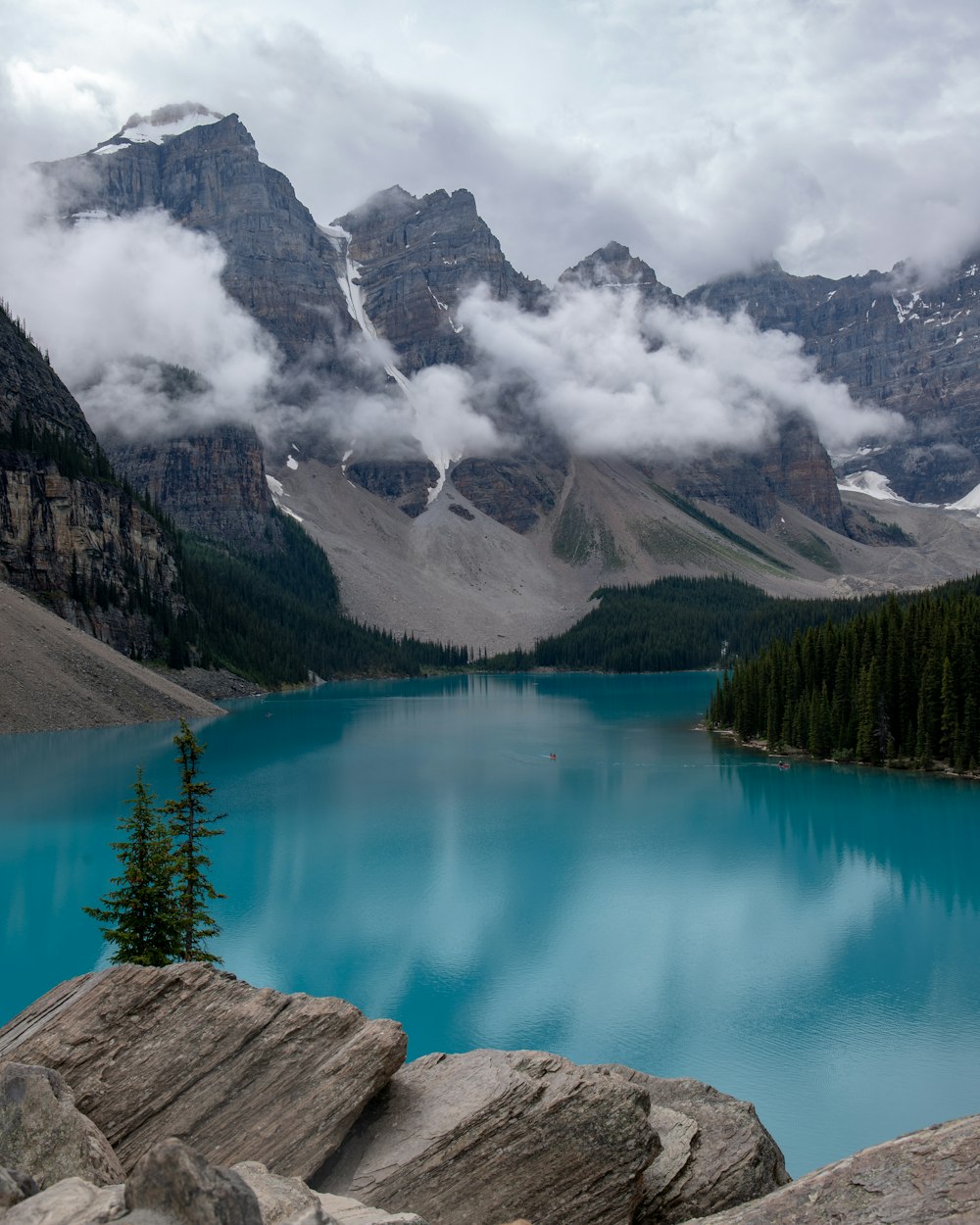 body of water near trees and mountain