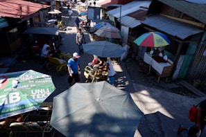 A colorful street market in Lagos bustling with vendors and shoppers under bright sunlight