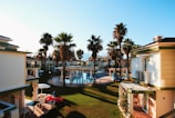 white buildings and hotel near swimming pool during daytime