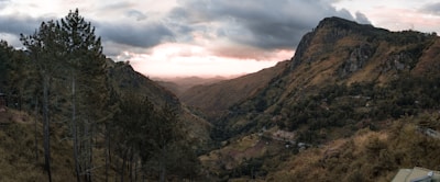 A scenic view of a mountain road during a sunset.