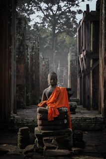 Statue of the Buddha draped with orange robe 
