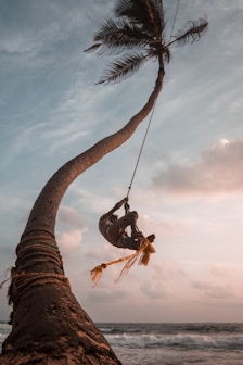low-angle photography of man hanging on rope