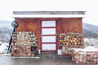 Rustic wooden woodshed standing neatly beside a home garden