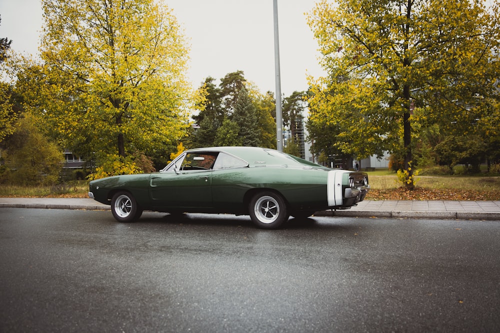 green muscle car traveling on road