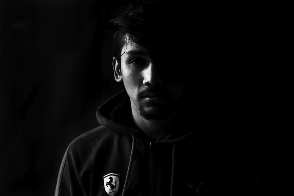 grayscale photo of man wearing Ferrari hoodie