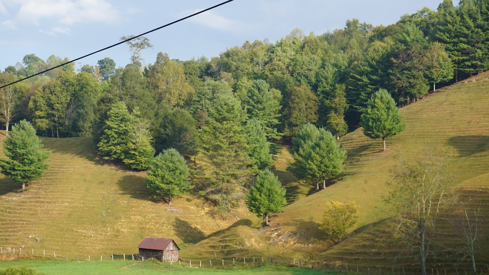 brown barn across hills and trees