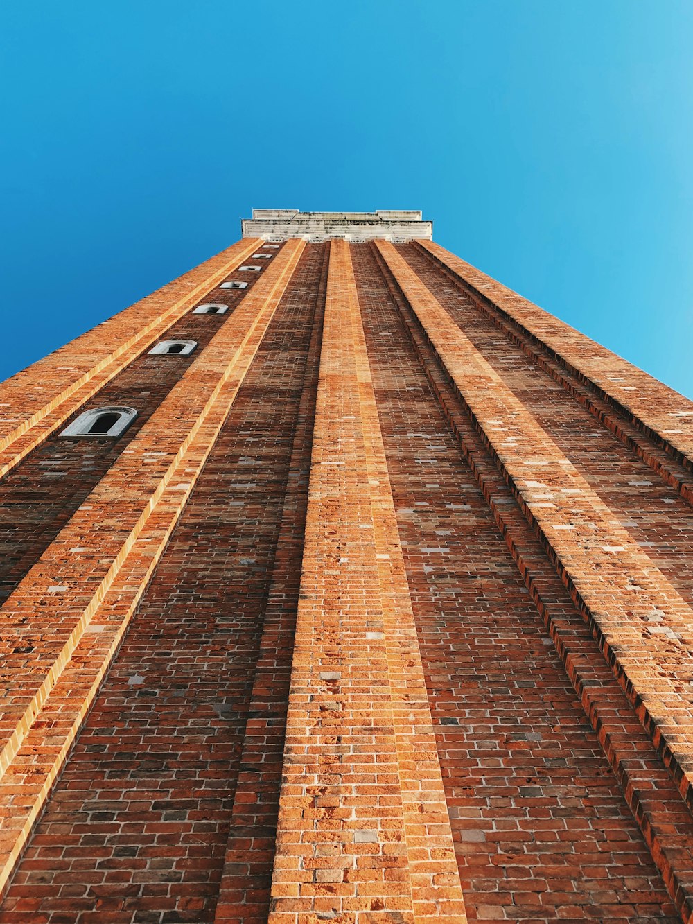 Fotografía de ángulo bajo de un edificio de ladrillo marrón bajo un cielo despejado