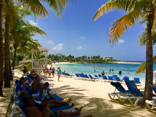 A bright tropical beach scene with smiling families enjoying the sun and surf.