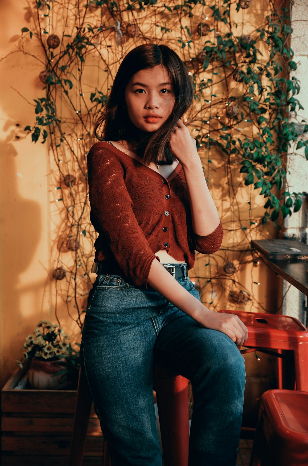 woman sitting on stool holding her hair