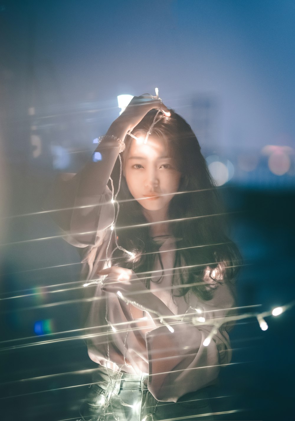 woman holding string lights