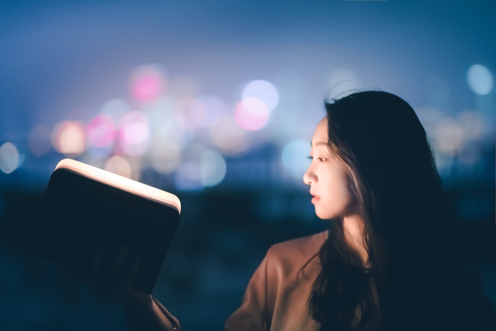 woman opening a notepad with light