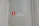 A wall with a small, rectangular red sign featuring a white fire extinguisher icon. Below the sign are three diamond-shaped labels with the numbers 403, 404, and 405. The wall is in a neutral color with a visible seam reinforced by metallic rivets.
