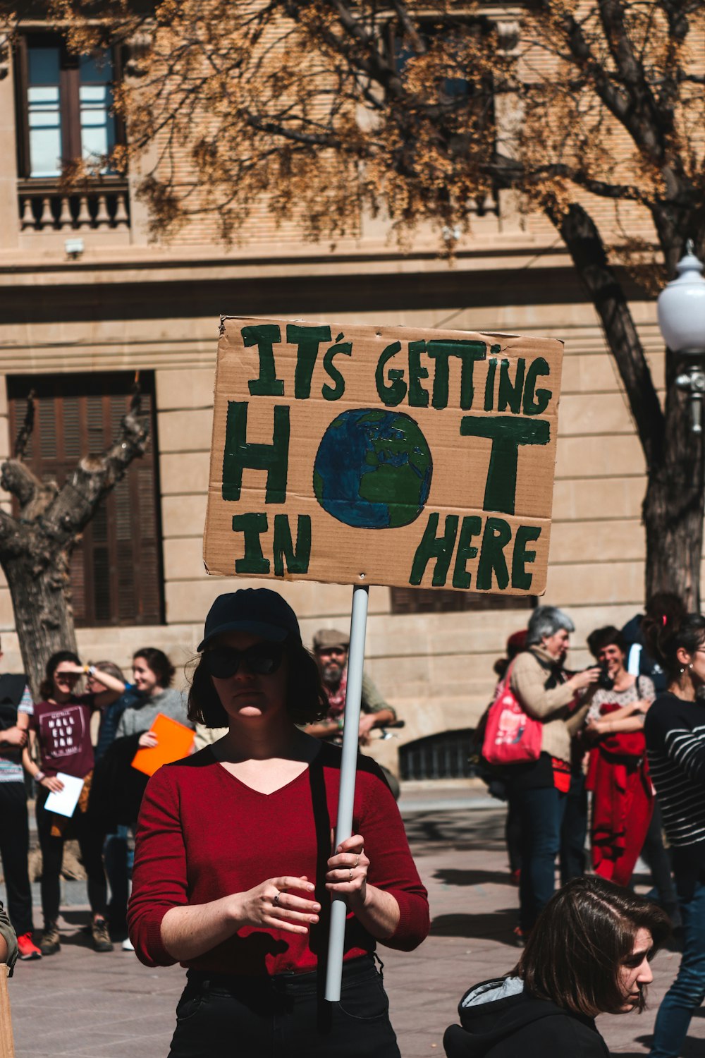 woman holding signboard during daytime