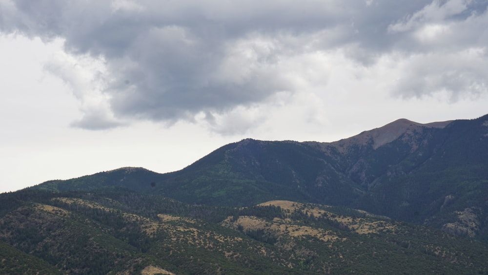 green mountain under cloudy sky