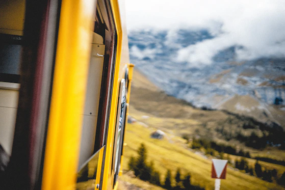 View from a train window overlooking a mountain landscape.