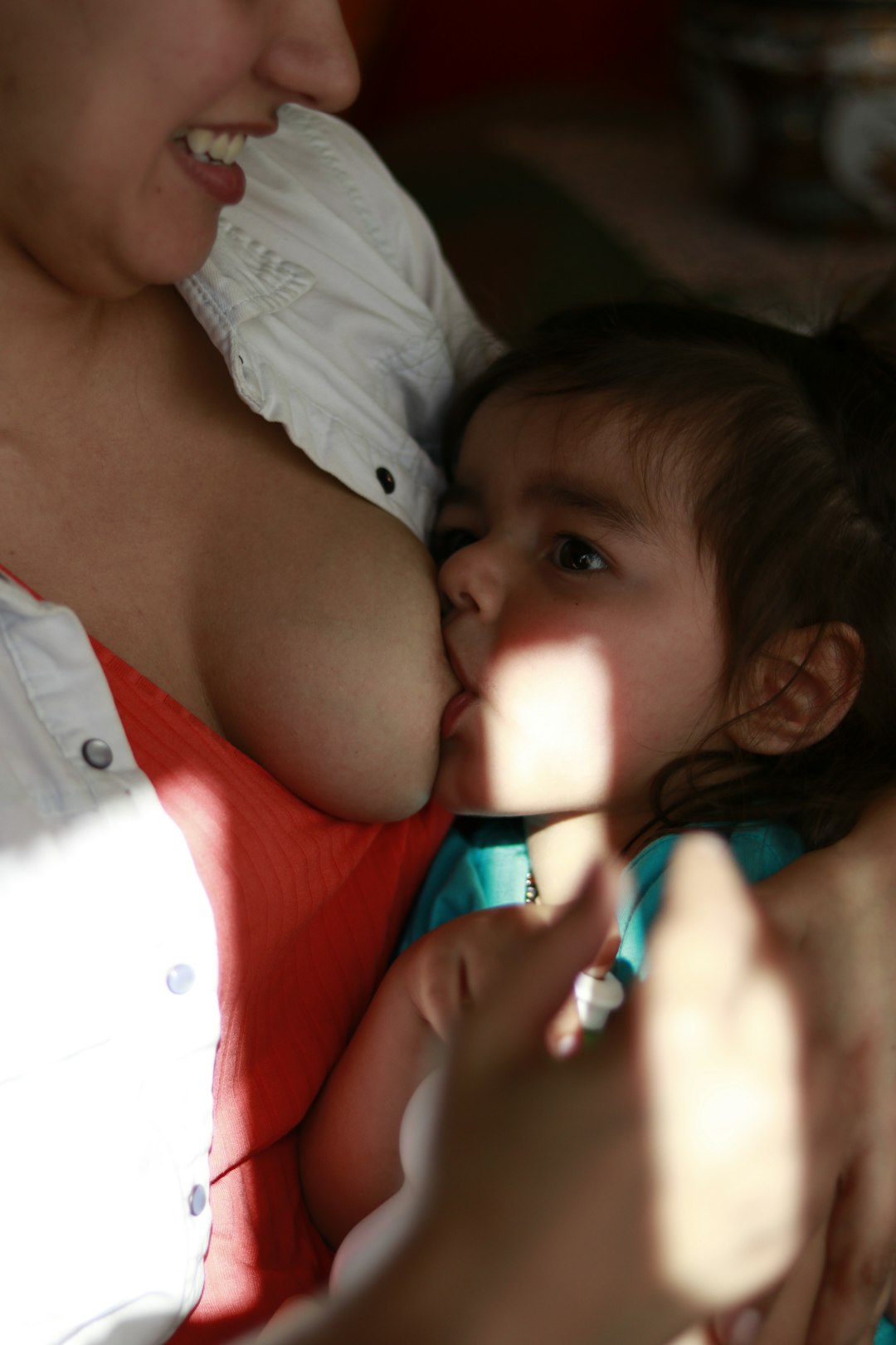 shallow focus photo of woman breast feeding baby