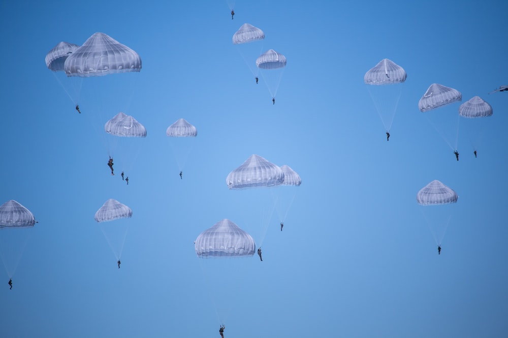 Paracaídas blancos durante el día Foto