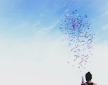 woman throwing confetti into blue sky