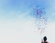 woman throwing confetti into blue sky