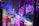 Vibrant colors and abstract patterns create a dynamic and immersive visual experience. The image features overlapping layers of translucent fabric or screens, onto which bright, saturated colors like purple, pink, green, and blue are projected. Organic shapes and abstract designs evoke a sense of movement and fluidity, possibly suggesting elements of nature or fantasy.