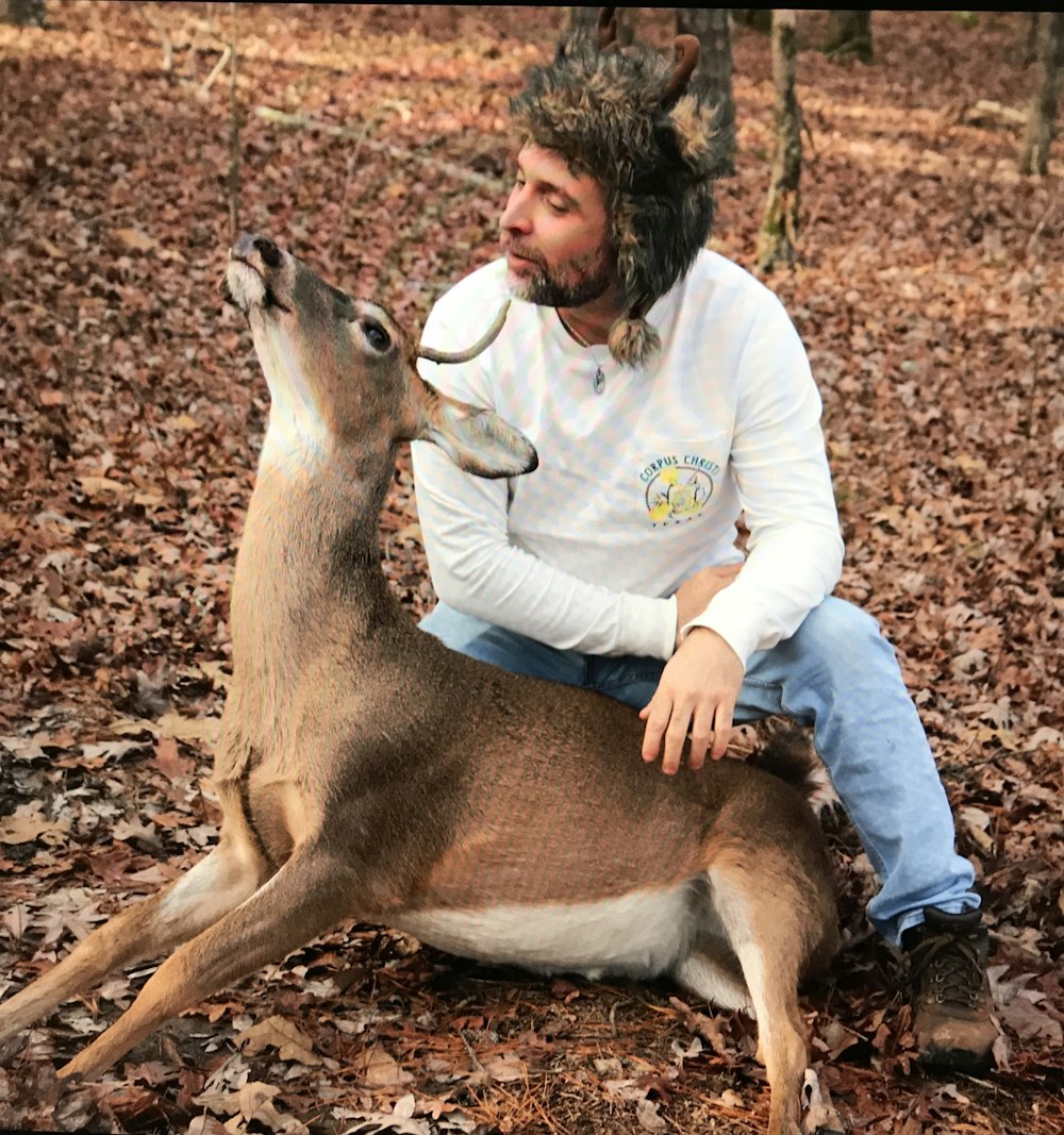 person sitting near deer