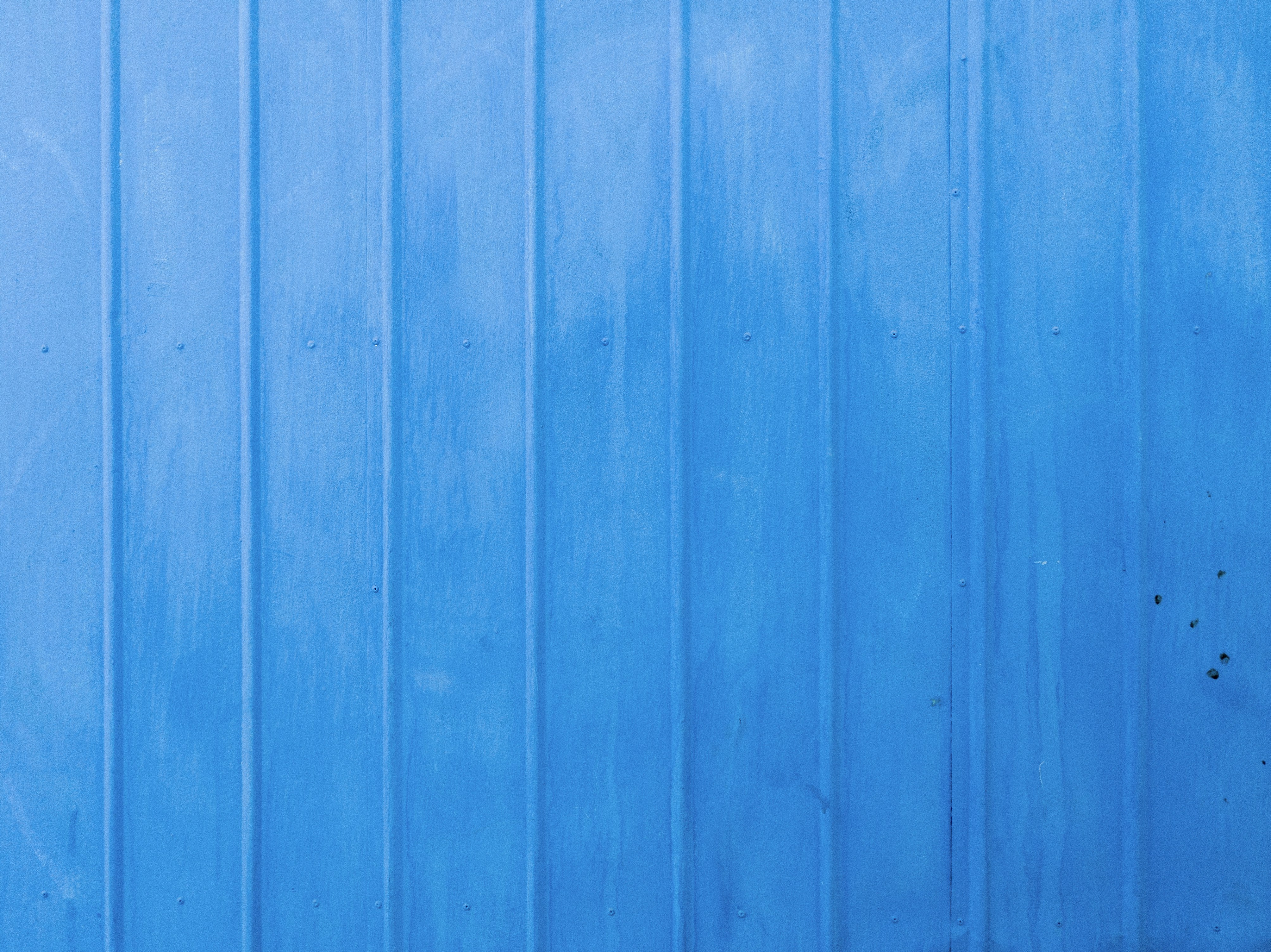 a blue metal wall with a red fire hydrant