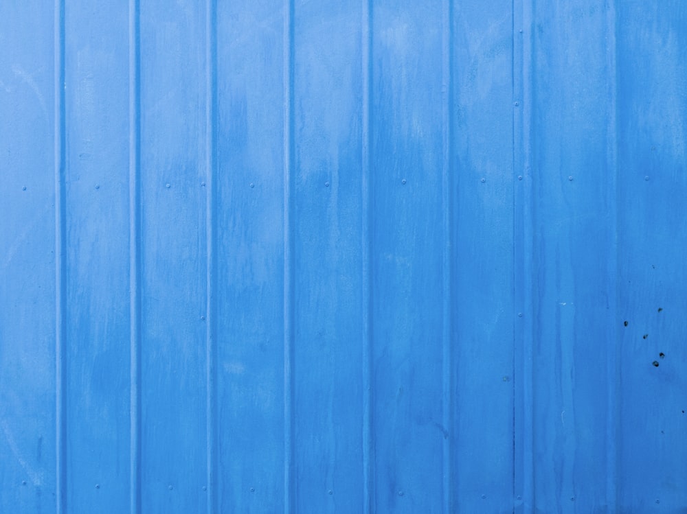 a blue metal wall with a red fire hydrant