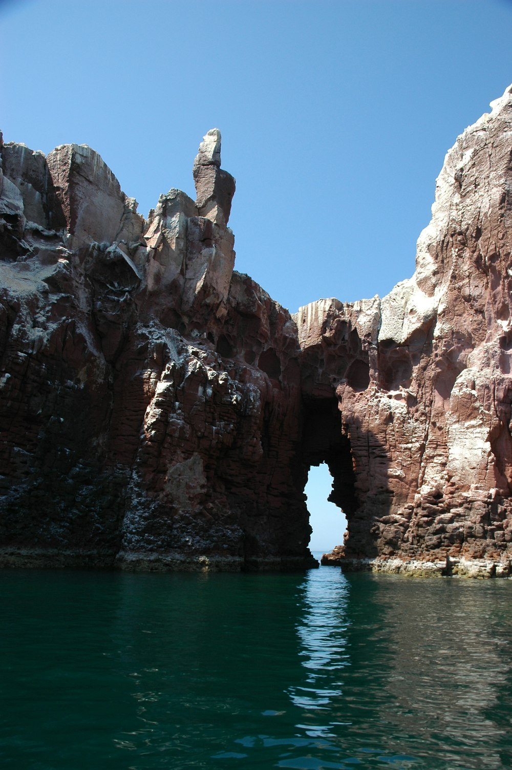 rock formation in sea under blue sky