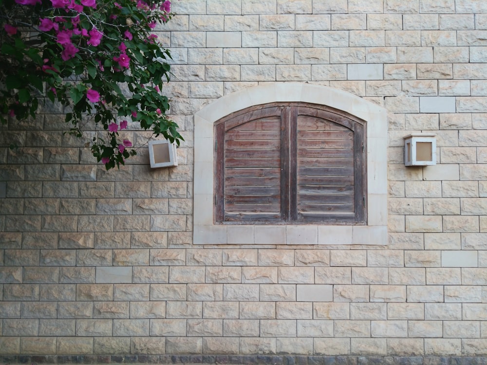 white brick building with closed brown wooden French windows