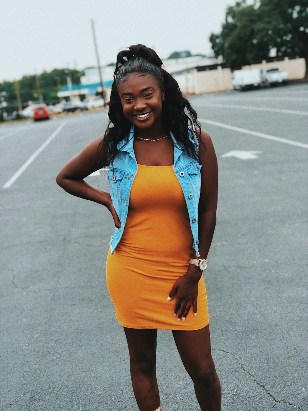 woman wearing orange dress and blue denim vest