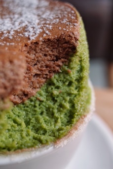 Close-up of a delicate Japanese sponge cake with a soft, airy texture and a light dusting of powdered sugar on top.