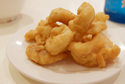 Close-up of golden fried Oreos with a dusting of powdered sugar on a rustic plate.