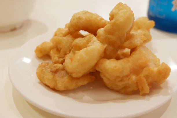 Close-up of a golden, crispy fried Oreo resting on a vibrant plate.