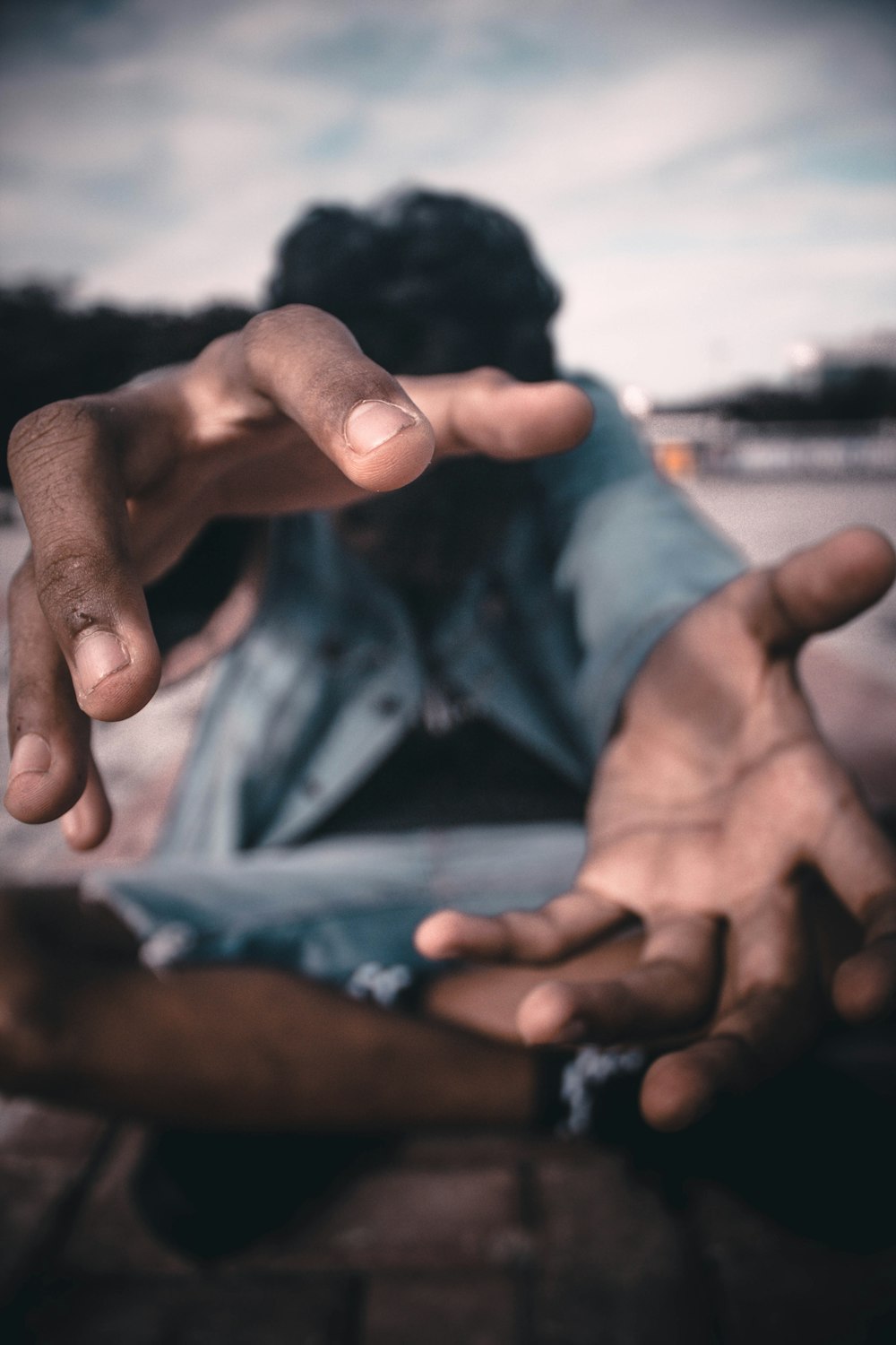 a man sitting on the ground with his hands in the air